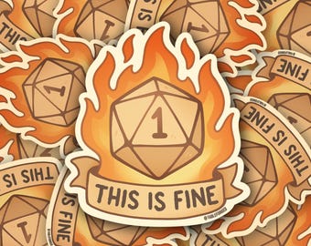 May include: A sticker featuring a D20 die with the number 1, engulfed in flames. The text "THIS IS FINE" is on a banner below the die. The sticker has a cartoon style with orange and tan colors.