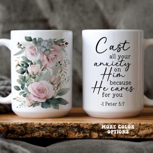 May include: White ceramic mug with a floral design featuring pink roses and green leaves. The other side of the mug has the text "Cast all your anxiety on Him because He cares for you -1 Peter 5:7".