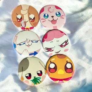 May include: Six colorful, round pinback buttons with cartoon animal faces. The buttons feature a variety of designs, including a dog, cat, and bird, with expressive eyes and vibrant colors. These buttons are perfect for adding a touch of fun to any outfit or accessory.