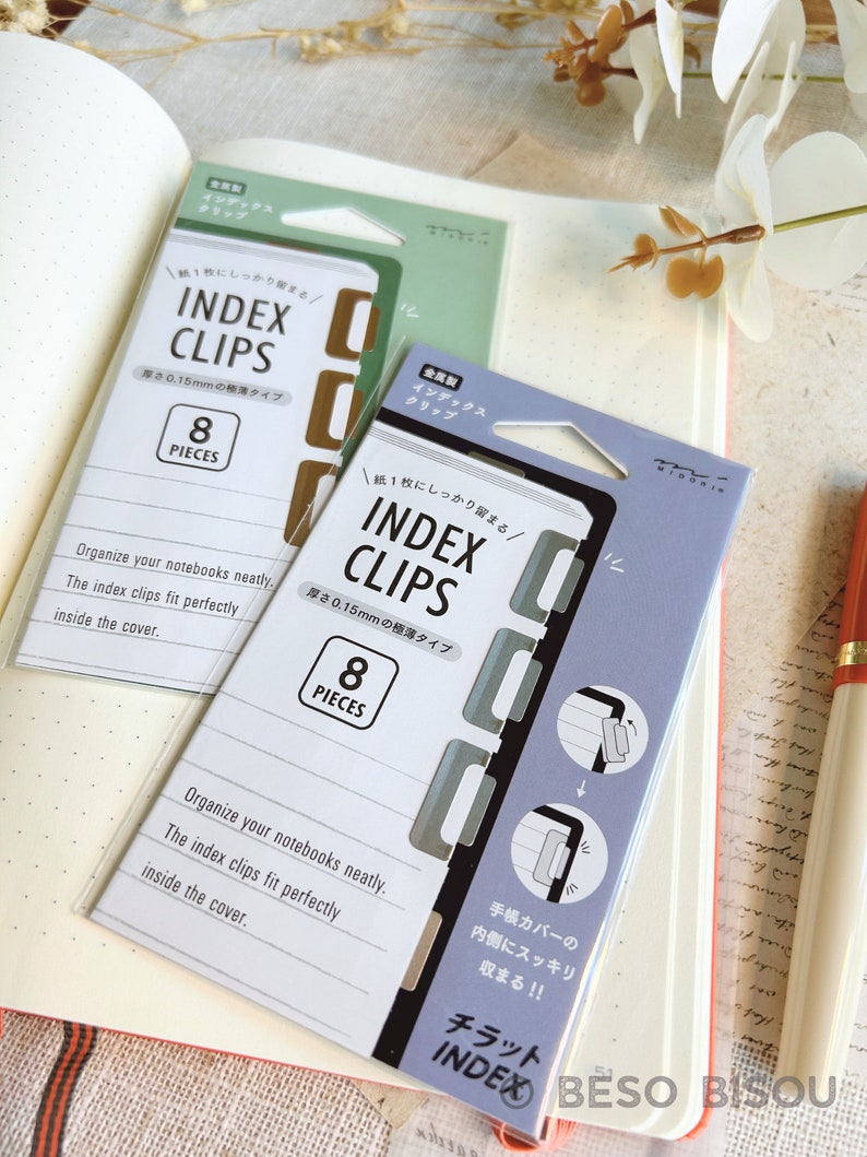 Op de afbeelding: Twee pakjes indexclips voor notitieboekjes. De pakjes zijn beide lichtblauw en grijs met witte tekst. De tekst op de pakjes luidt "Index Clips" en "0,15 mm Thin Type". Elk pakje bevat 8 stuks.