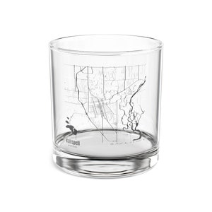 May include: A clear glass tumbler with a detailed black and white map of Kalispell, Montana. The city's name and state are printed at the bottom, along with coordinates. The glass has a rounded shape.