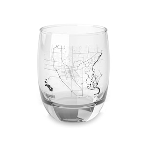 May include: A clear, stemless glass with a black and white map design. The map depicts the city of Kalispell, Montana, with the city's name printed at the bottom. The glass has a rounded base and a wide opening.
