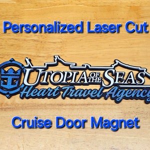May include: Personalized laser cut cruise door magnet featuring the Utopia of the Seas cruise ship with the text "Heart Travel Agency".
