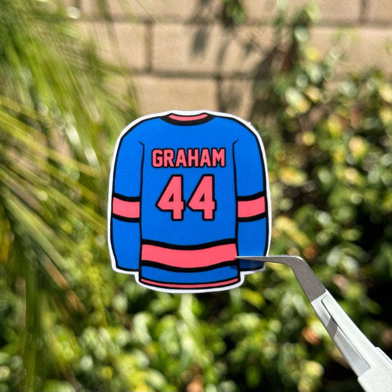 May include: A blue and pink hockey jersey sticker with the name "GRAHAM" and the number "44" on the back.