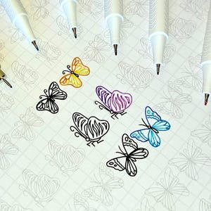 May include: A collection of fine-tipped pens and colorful butterfly illustrations. The butterflies are drawn in black ink and colored with yellow, purple, and blue. The pens are white with black and colored tips, and one pen is olive green.