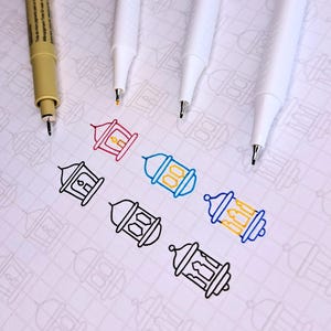 Puede incluir: Una hoja de papel blanca con un patrón de cuadrícula. Seis linternas delineadas están coloreadas con marcadores de diferentes colores. Los marcadores están sobre el papel.