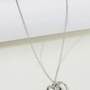 Delicate,modern, silver and gold sweet necklaces with two simply intertwined hearts. Perfect for any occasion. image 2