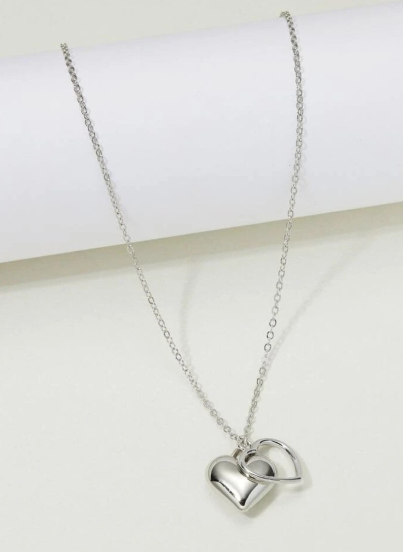 Delicate,modern, silver and gold sweet necklaces with two simply intertwined hearts. Perfect for any occasion. image 2