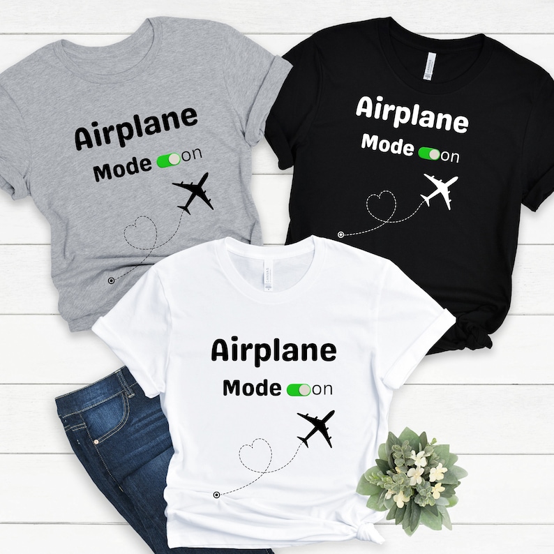 May include: Three t-shirts with the text "Airplane Mode on" and a silhouette of an airplane. The shirts are in gray, black, and white.