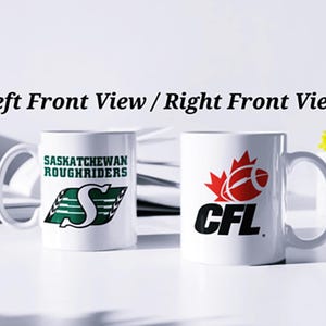 May include: Two white ceramic mugs with different designs. The mug on the left has a green and white logo that says "Saskatchewan Roughriders" with a green "S". The mug on the right has a red and white Canadian flag with a football and the text "CFL".
