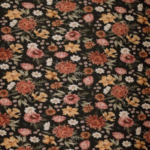Peut inclure: Tissu noir avec un motif floral composé de fleurs roses, orange et jaunes sur un fond foncé.