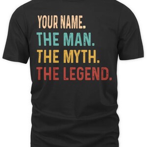 May include: Black t-shirt with a vintage-style graphic that reads "YOUR NAME. THE MAN. THE MYTH. THE LEGEND."