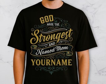 May include: Black t-shirt with a gold and teal design. The text reads "GOD made the STRONGEST and Named Them YOURNAME" in a decorative font. The shirt is a crew neck style.