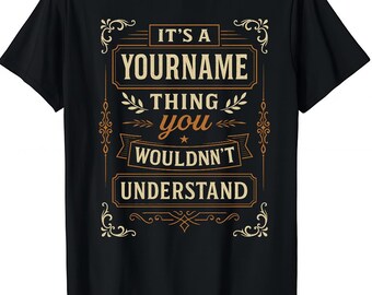 May include: Black t-shirt with a gold and white graphic design. The design includes the text "IT'S A YOURNAME THING YOU WOULDN'T UNDERSTAND" in a decorative font. The shirt is a classic crew neck style.