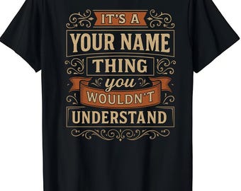 May include: Black t-shirt with a vintage-style design. The text reads "IT'S A YOUR NAME THING YOU WOULDN'T UNDERSTAND" in a tan and orange color scheme. The design includes decorative flourishes.