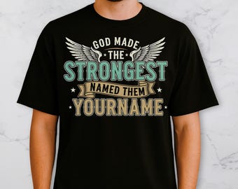 May include: Black t-shirt with a graphic design. The design includes the text "GOD MADE THE STRONGEST NAMED THEM YOURNAME" in white, teal, and gold. The design also features angel wings.