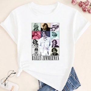 May include: White t-shirt featuring a grid of nine images of Bailey Zimmerman, with the name "BAILEY ZIMMERMAN" printed in black below the images. The images are in a variety of poses and settings.