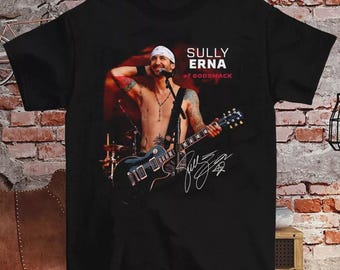 May include: Black t-shirt with a photo of Sully Erna of Godsmack playing a guitar. The text "Sully Erna of Godsmack" is printed on the shirt. The shirt also has Sully Erna's signature.
