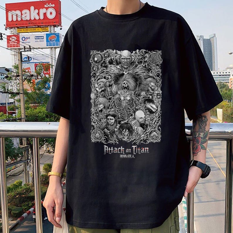 May include: Black t-shirt with a graphic print of characters from the anime Attack on Titan. The text "Attack on Titan" and the Japanese characters "進撃の巨人" are printed below the graphic.