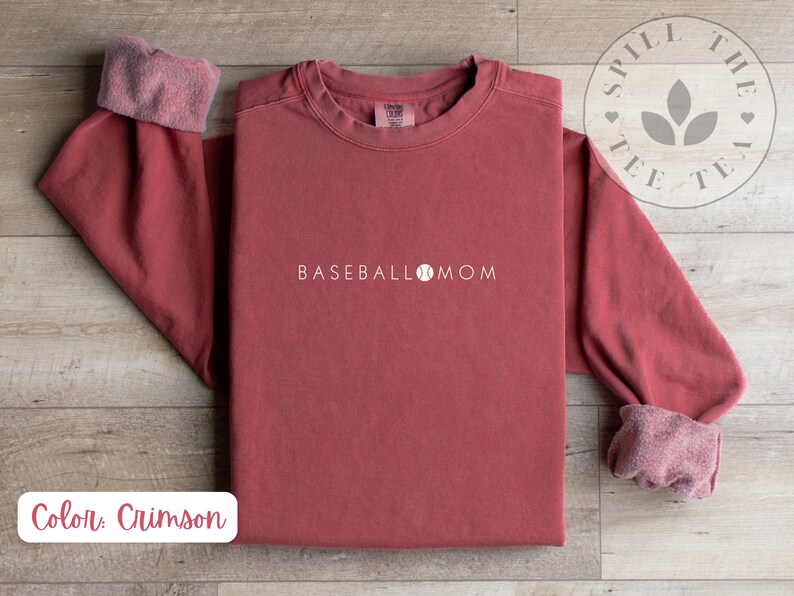 May include: Crimson red long-sleeved sweatshirt with the text "BASEBALL MOM" and a baseball graphic.