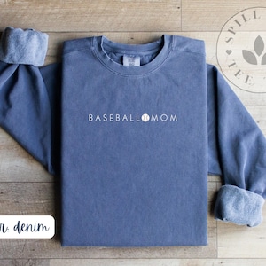 May include: A denim blue sweatshirt with the text "BASEBALL MOM" and a baseball graphic in white.