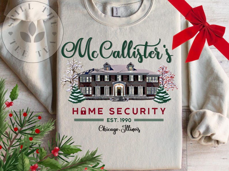 Puede incluir: Una sudadera beige de cuello redondo con un gr&aacute;fico de una casa grande en invierno con &aacute;rboles nevados. El texto dice "McCallister's HOME SECURITY EST. 1990 Chicago, Illinois" en letras verdes, rojas y negras con un icono de candado en la palabra home.