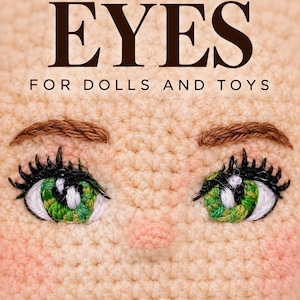 Peut inclure: Un visage de poupée crocheté avec des yeux verts brodés, des cils noirs, des sourcils bruns et un petit nez. Le texte EYES FOR DOLLS AND TOYS est imprimé en brun foncé sur le haut de la surface crochetée de couleur pêche clair.