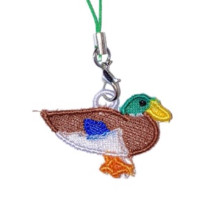 May include: Embroidered duck charm with a green head, yellow beak, and brown body. The duck has a blue patch on its wing and white accents. It hangs from a green cord with a silver clasp, suitable for a keychain or phone accessory.