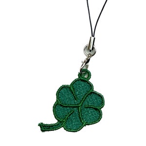 May include: A green four-leaf clover charm attached to a black string phone charm.