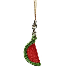 May include: A red and green watermelon slice charm attached to a gold string.