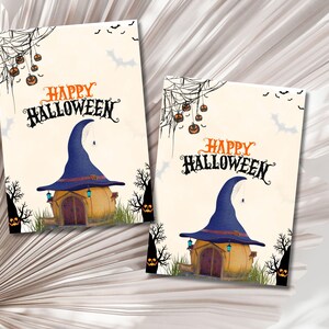 May include: Two printable cards with a Halloween theme. Each card features a witch's hat shaped house with a door and windows. The text "Happy Halloween" is written in black script on each card.