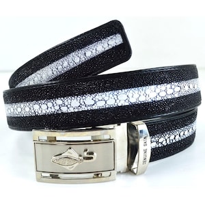 May include: A black leather belt with a white stripe and a silver buckle. The buckle has a fish design and the words "GENUINE SKIN" engraved on it.