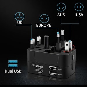 May include: A black universal travel adapter with multiple plug configurations for UK, Europe, Australia, and USA. Features dual USB ports for charging devices. Includes diagrams for each plug type.