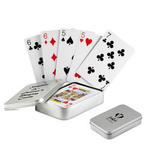 May include: A deck of playing cards in a silver tin case. The cards are fanned out, showing the six of clubs, six of diamonds, five of spades, five of hearts, and seven of clubs. The open tin case has text that reads "Stephen & Denise's Playing Cards."