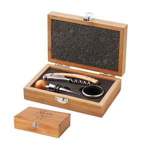 May include: A wooden wine tool set including a corkscrew, bottle stopper, and other accessories. The set is presented in an open wooden box with a black interior. A smaller wooden box is below, with the name "Steve" and the text "Best Man" engraved.