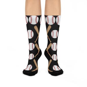 Könnte beinhalten: Ein Paar schwarze Socken mit einem sich wiederholenden Muster aus weißen Baseballs und braunen Baseballschlägern.
