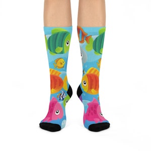 May include: A pair of colorful socks with a blue background and a variety of fish designs. The socks feature pink, orange, yellow, green, and blue fish.