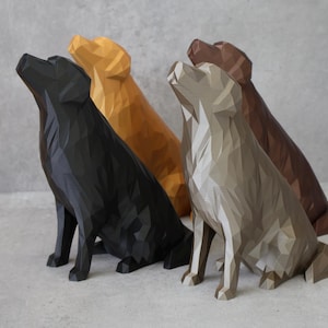 May include: Four geometric dog sculptures in black, gold, grey, and brown. The dogs are in a sitting position, with their heads tilted upwards. The sculptures have a modern, angular design against a grey background.