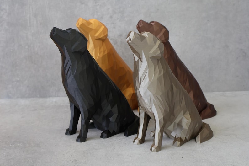 May include: Four geometric dog sculptures in black, gold, grey, and brown. The dogs are in a sitting position, with their heads tilted upwards. The sculptures have a modern, angular design against a grey background.