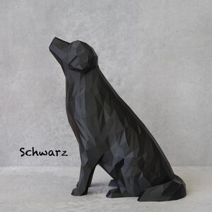 May include: A black geometric dog sculpture with a faceted design, sitting and looking upwards. The word "Schwarz" is written in a cursive font on the left side of the sculpture.