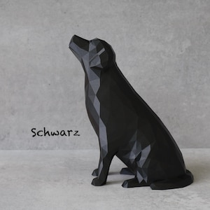 May include: A black geometric dog sculpture in a sitting position, with its head tilted upwards. The word "Schwarz" is written in a script font on the left side of the image. The sculpture is on a light gray surface.