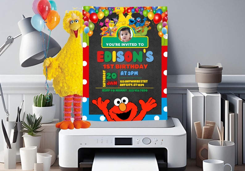 May include: A Sesame Street themed birthday invitation with a photo of a child in the center. The invitation is printed on a white printer with a yellow Big Bird plush toy holding balloons in the background. The text on the invitation reads "You're invited to Edison's 1st Birthday, Saturday, Jan 20 at 3pm, 123 Anywhere St, Any City, St 1234, RSVP to Mommy: 123 456 7890".
