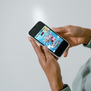 May include: A smartphone displaying a colorful birthday invitation for a child named "Larry" turning three. The invitation features a cartoon image of a superhero and a cat. The text on the invitation reads "Join us to Celebrate! Larry is turning 3!" and includes the date, time, and location of the party.