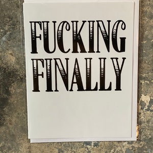 May include: White card with black text that reads "FUCKING FINALLY" in a bold, decorative font.