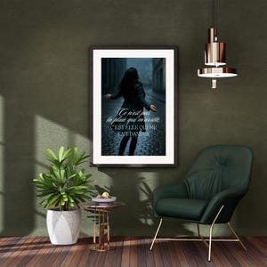 Peut inclure: Impression d'art encadrée représentant une femme en manteau sombre dansant sous la pluie. L'impression a un cadre noir et comprend le texte français "Ce n'est pas la pluie qui m'arrête, c'est elle qui me fait danser."