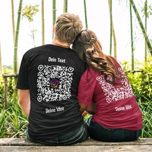 Può includere: Due persone indossano magliette nere e rosse con un codice QR e il testo "Dein Text" e "Deine Idee" sul retro.