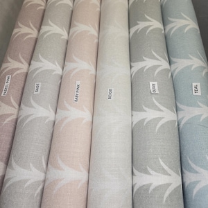 Op de afbeelding: Zes stofstalen met een wit bladmotief op een textuur achtergrond. De stalen zijn in de kleuren pastelroze, salie, babyroze, beige, olijf en teal.