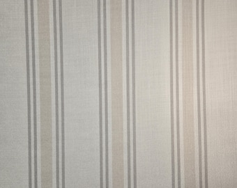 Puede incluir: Una tela blanca con rayas verticales en tonos grises y beige.