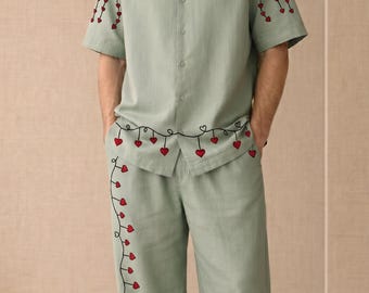 Conjunto coordinado de lino y algodón verde salvia, camisa y pantalón con bordado de corazón, atuendo vacacional ideal para la playa.