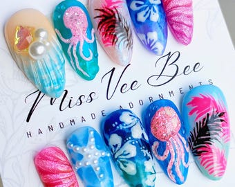 May include: Set of ten colorful fake nails with various summer-themed designs, including seashells, starfish, jellyfish, and tropical flowers. The nails are labeled "Miss Vee Bee Handmade Adornments".